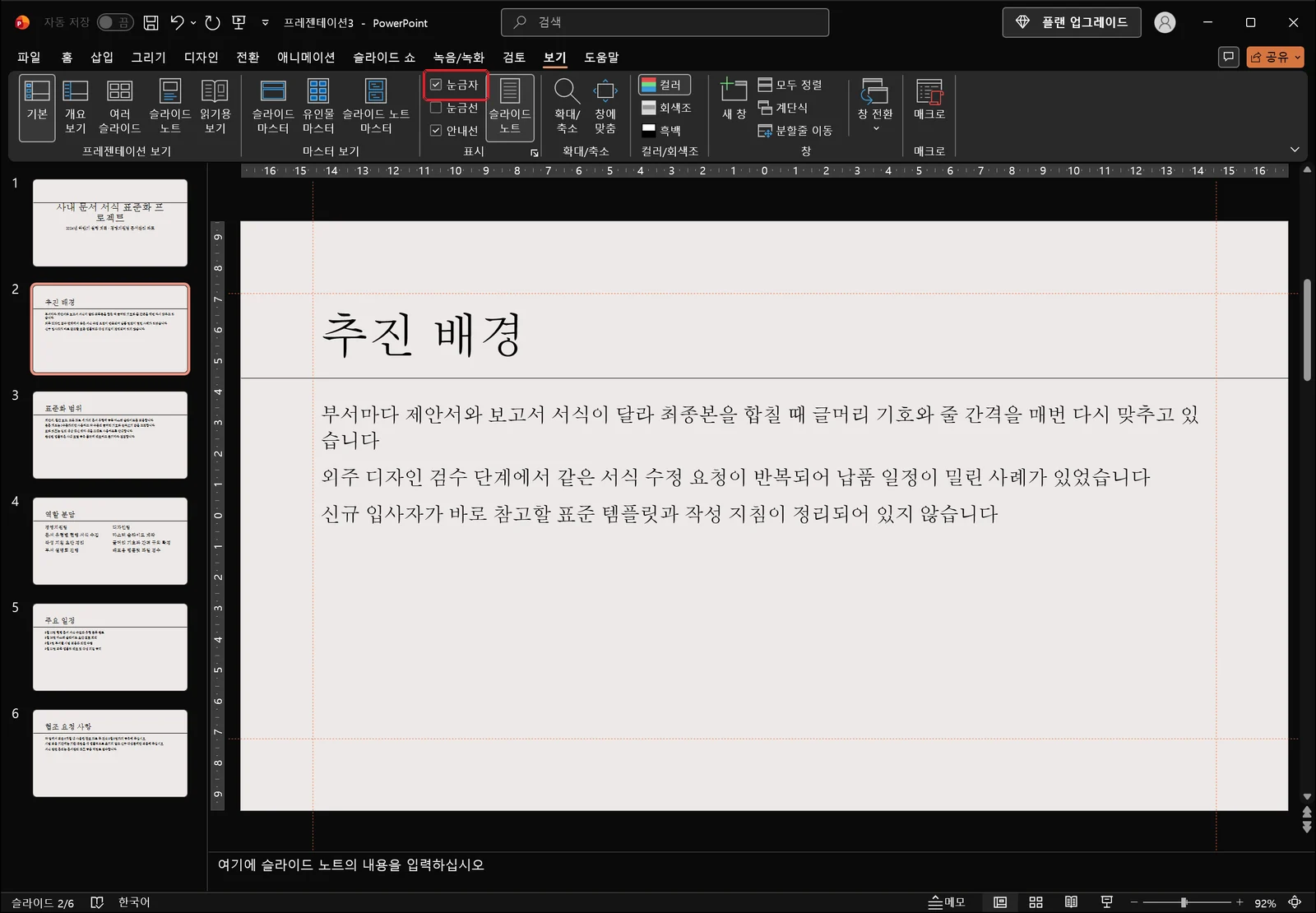 보기 탭의 '눈금자'가 빨간 상자로 강조되어 있고, 그 아래 슬라이드 편집 영역 위쪽에 눈금 숫자만 표시된 가로 눈금자가 나타난 화면. '안내선'도 함께 켜져 있어 슬라이드 가운데에 빨간 점선 안내선이 가로세로로 지나가는 파워포인트 화면