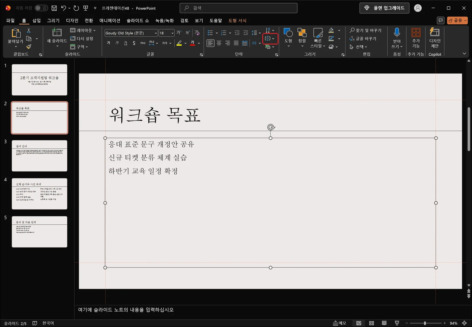 텍스트 상자가 흰 선택 핸들과 회전 핸들로 선택된 파워포인트 편집 화면. 홈 탭 단락 그룹 오른쪽 열에서 줄 간격 단추 옆, 텍스트 방향 아래에 있는 텍스트 맞춤 단추에 빨간 박스가 표시돼 있다